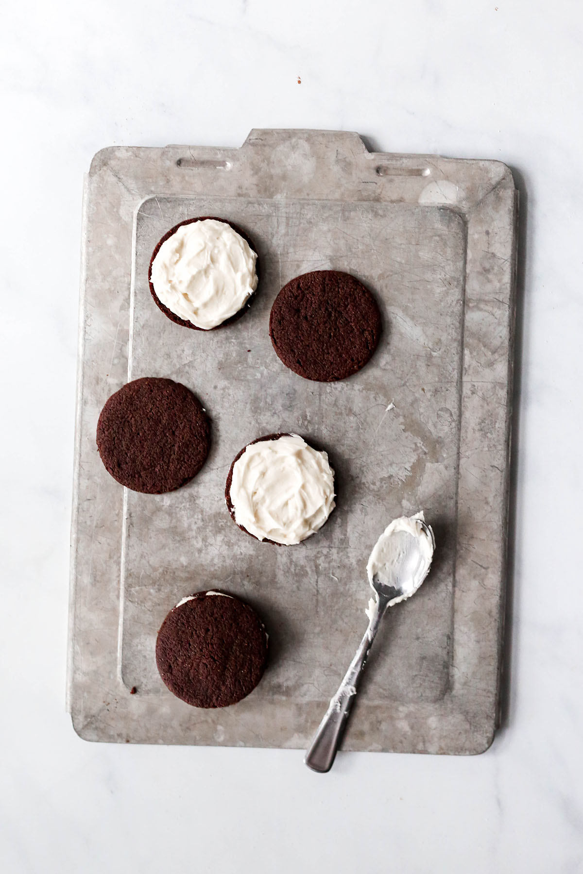 filling the vegan oreos with frosting