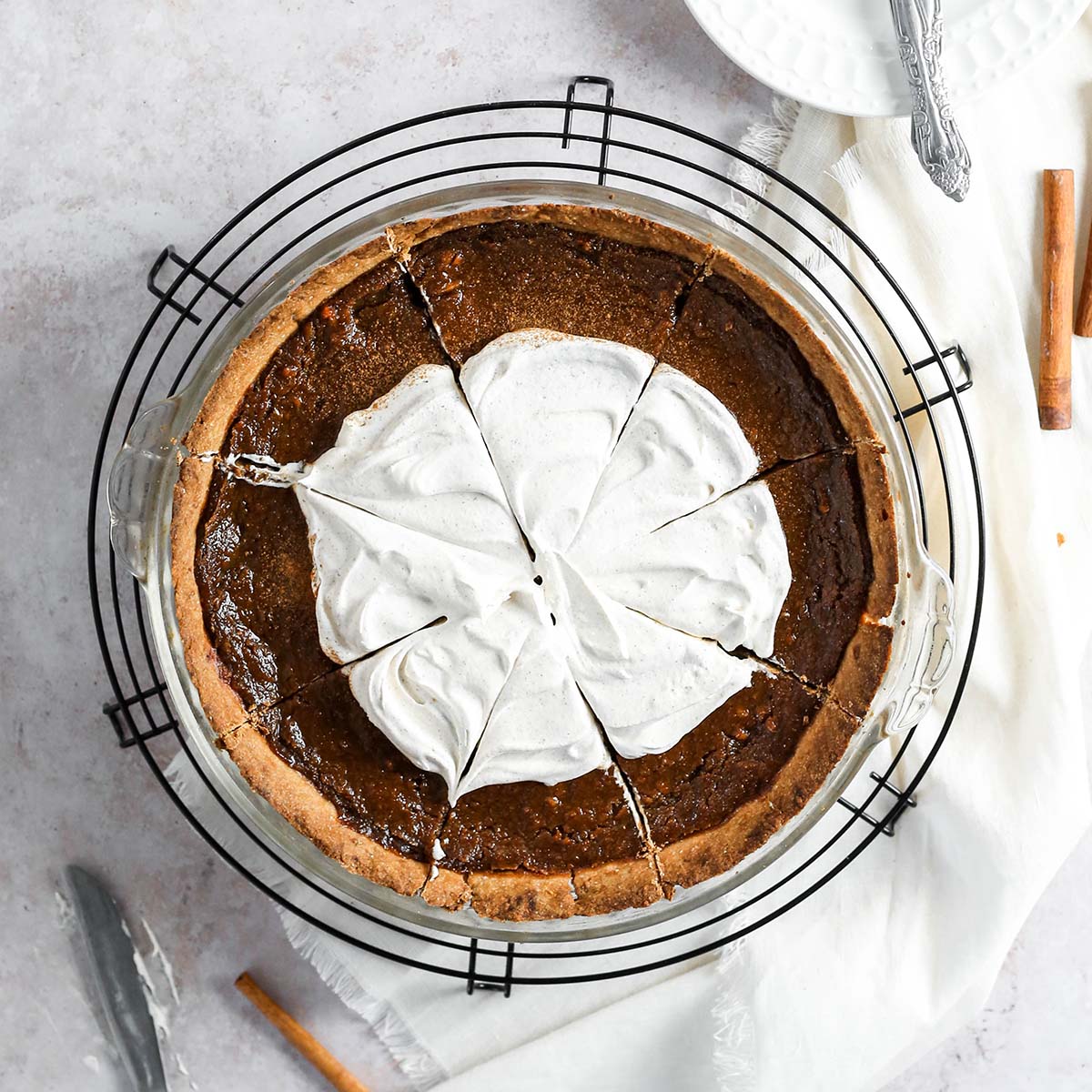 a sweet potato pie with coconut whipped cream on top