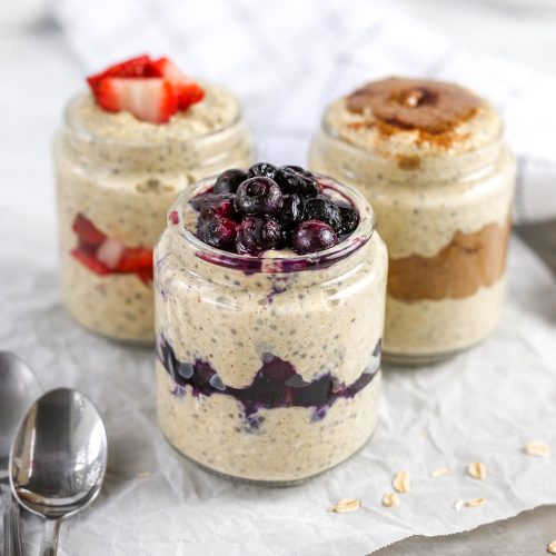 three jars of oatmeal, one with strawberries, one with blueberries, and one with peanut butter