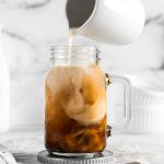 milk swirling in a glass of coffee
