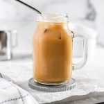 an almond milk latte inside a mason jar with a straw