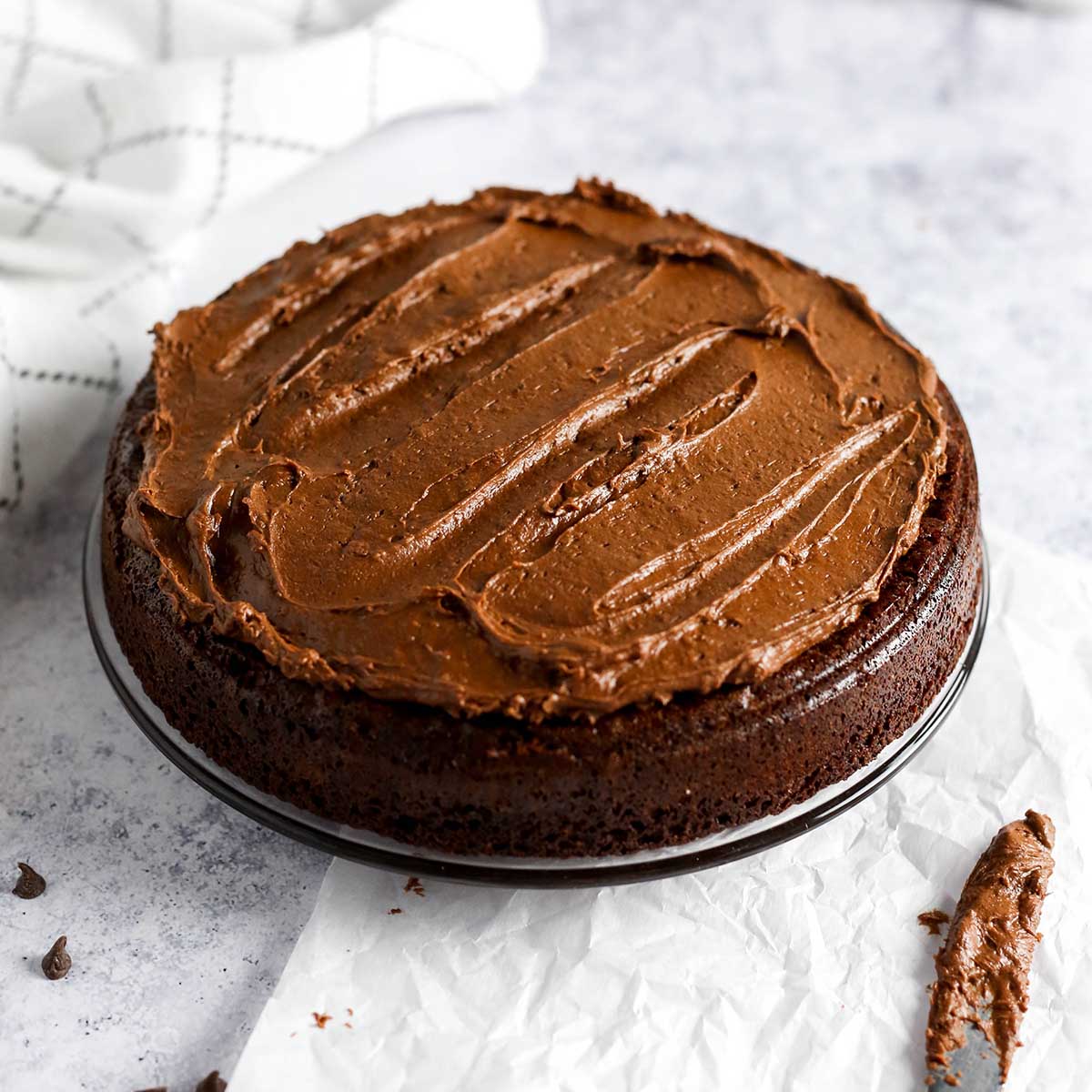 a chocolate cake on a plate with chocolate frosting