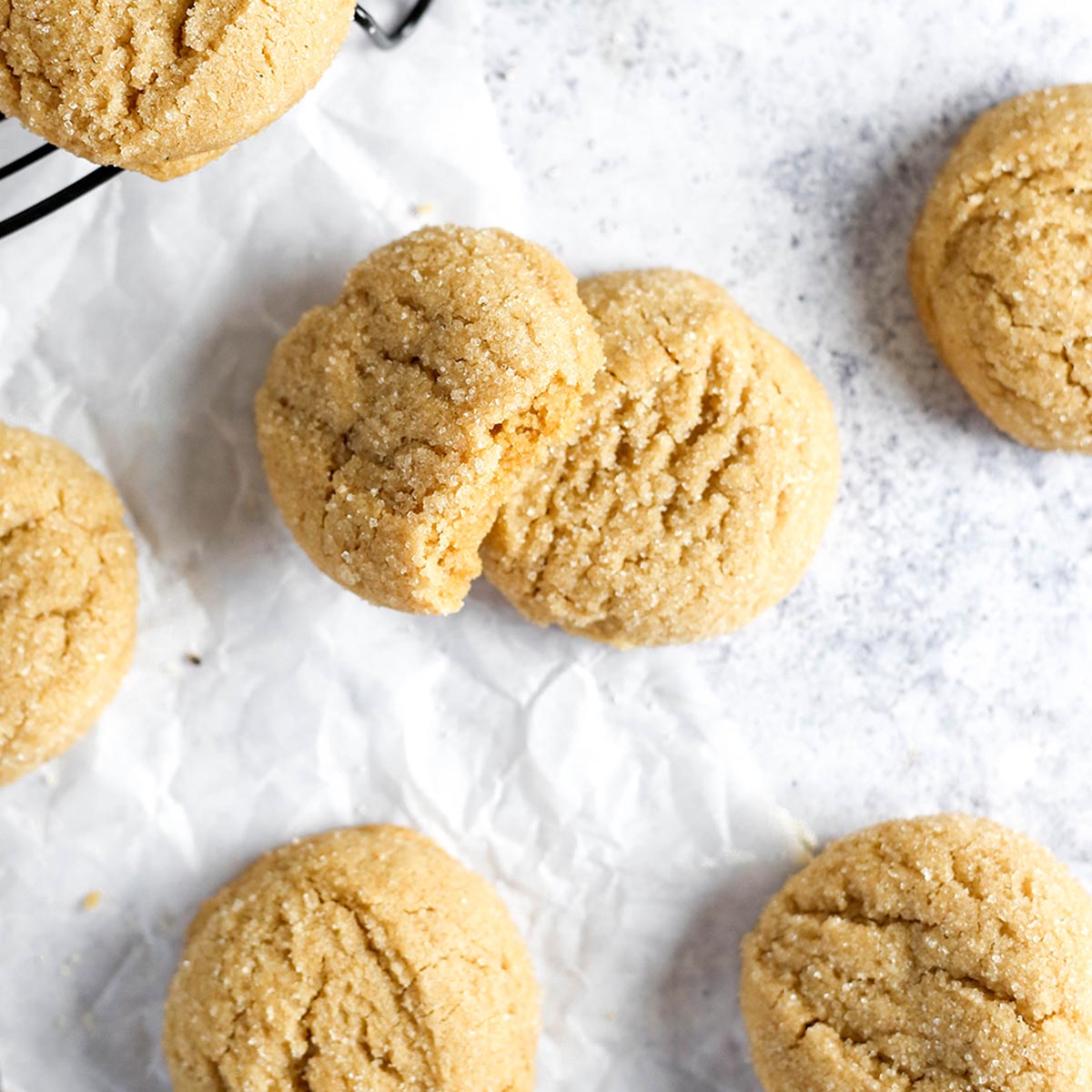 dairy free sugar cookies on a grey tabletop surface. The cookies have crackly tops.