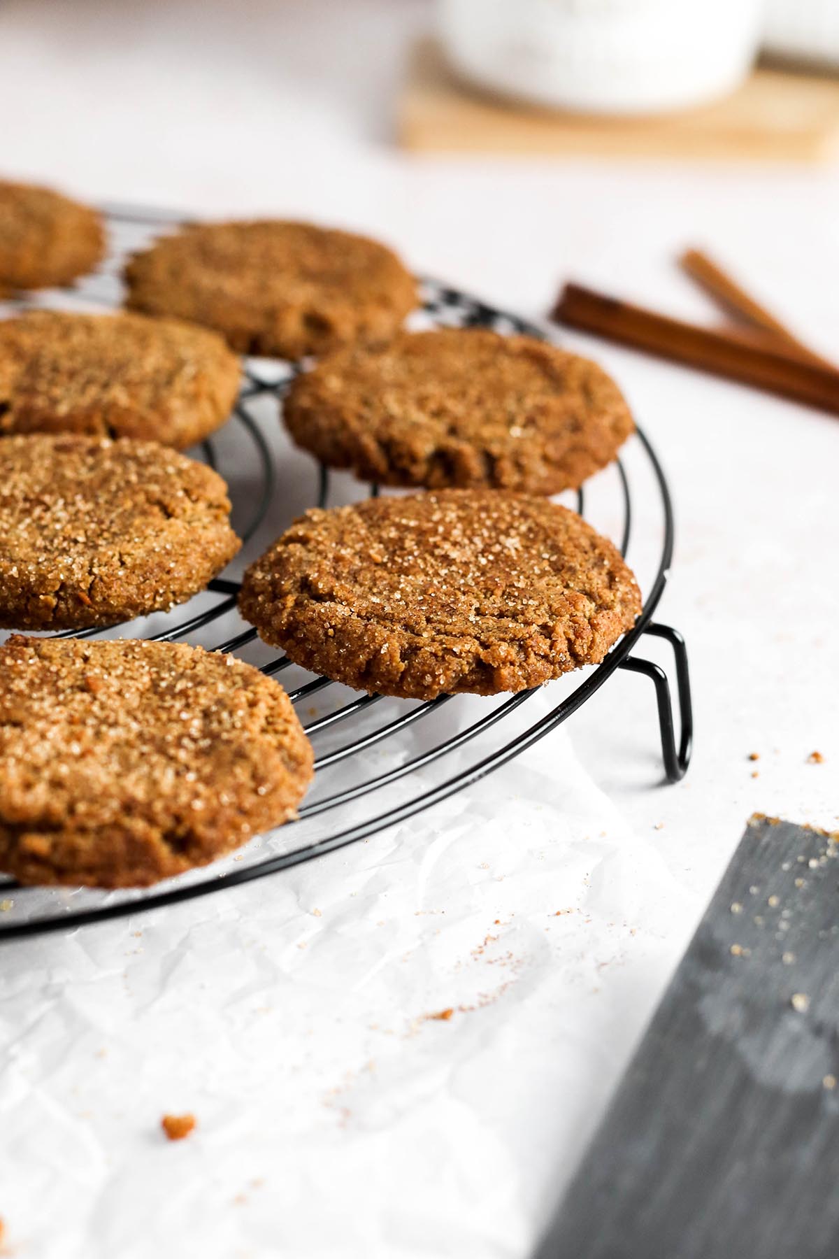 the vegan molasses cookies cooling on a black cooling rack