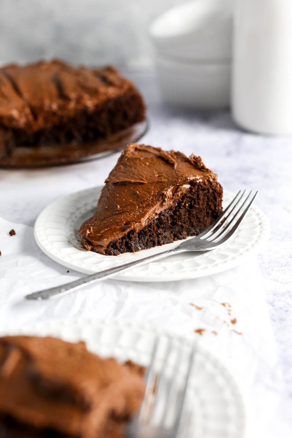 a thick slice of gluten free chocolate cake on a plate with a fork.