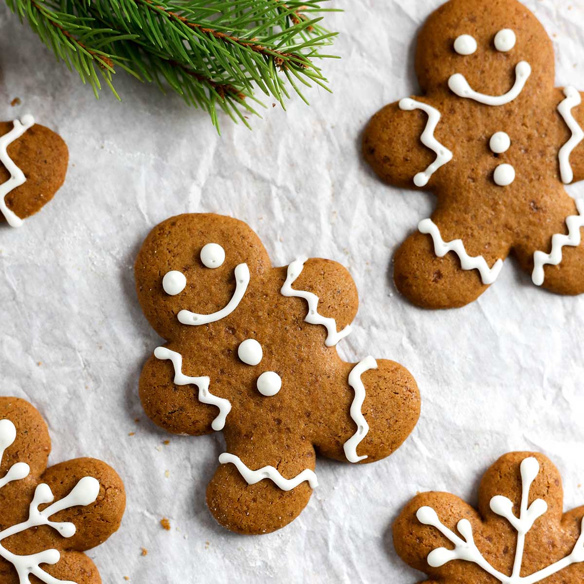 frosted gingerbread men cookies on parchment paper