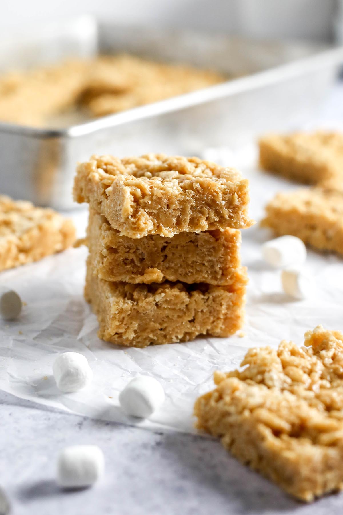 a stack of three peanut butter rice krispie treats, with marshmallows surrounding the stack.