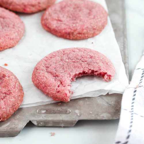 a pink sugar cookie on parchment paper