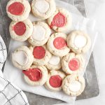 thumbprint cookies with icing on a grey tray